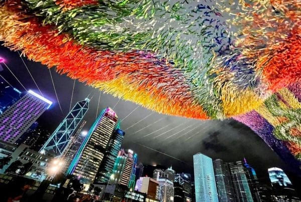 River of Light, part of the infamous Skynet Art Series, by Patrick Shearn of Poetic Kinetics at night with the city of Hong Kong behind it.